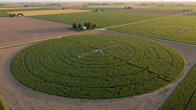 Aerial view of center-pivot irrigation circles forming a patchwork of green and brown fields across Nebraska farmland
